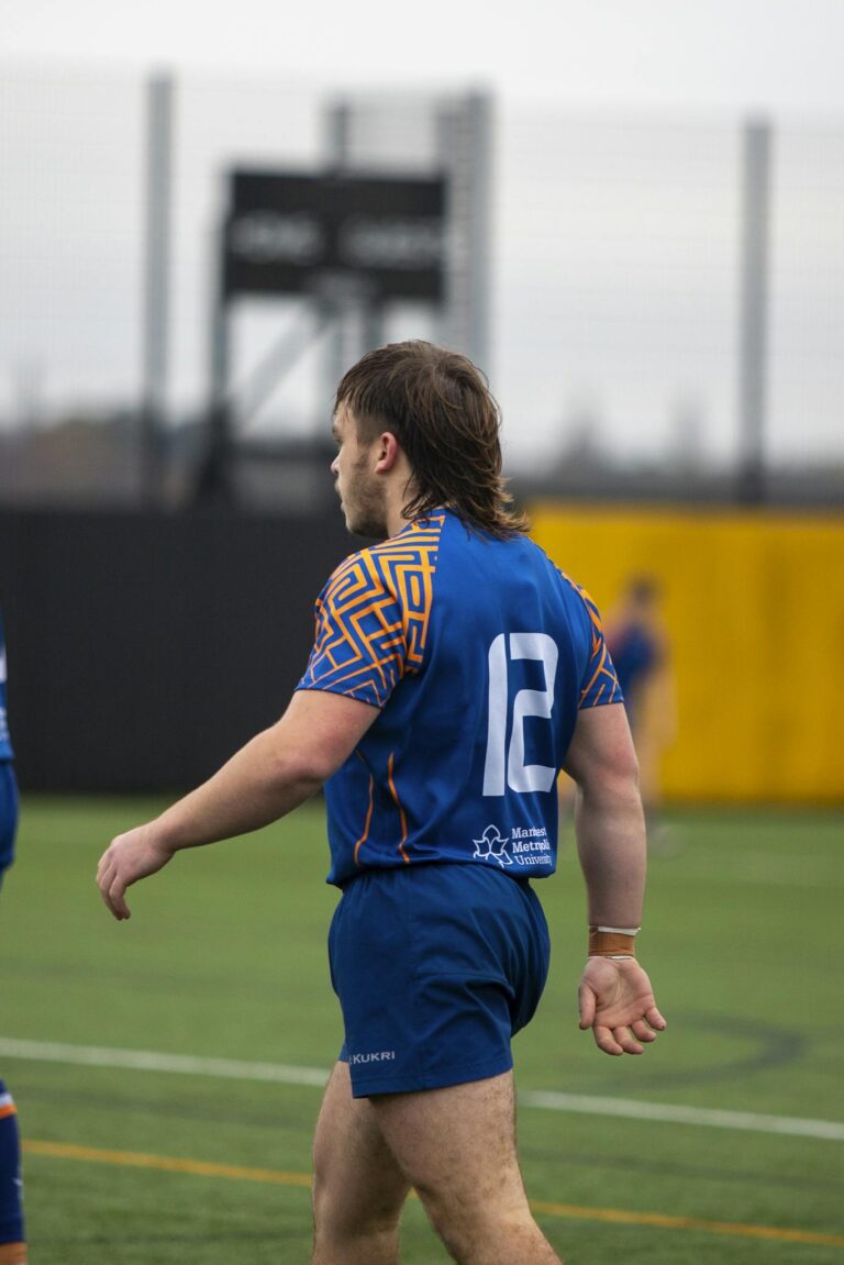 Action shot of a rugby player during a university sports match on field.