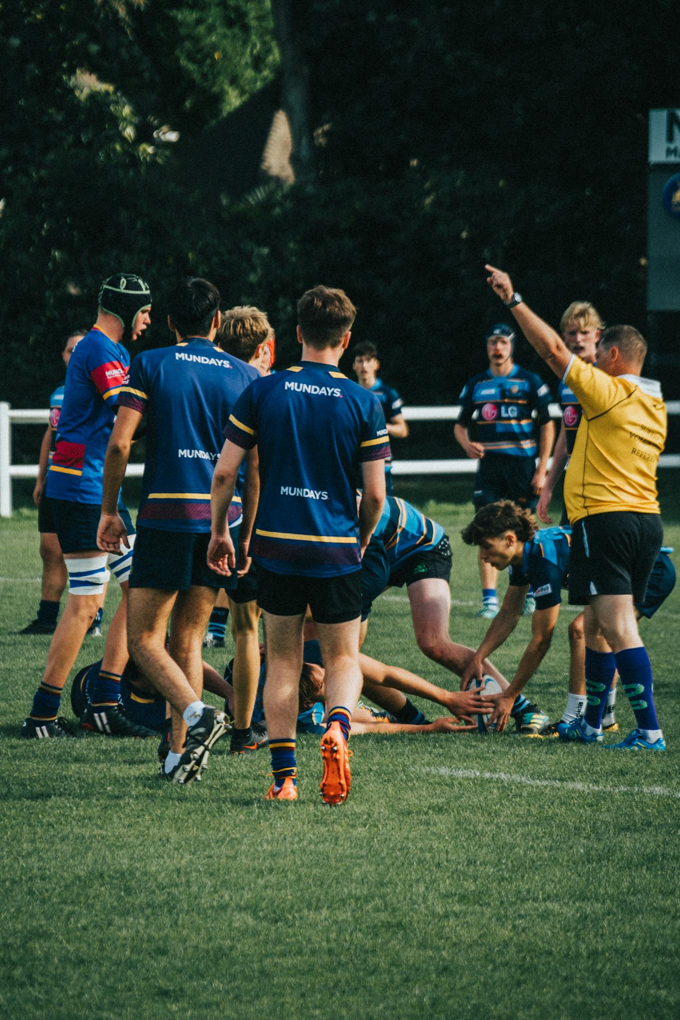 Rugby players in action during a match, showcasing teamwork and sport skill outdoors.